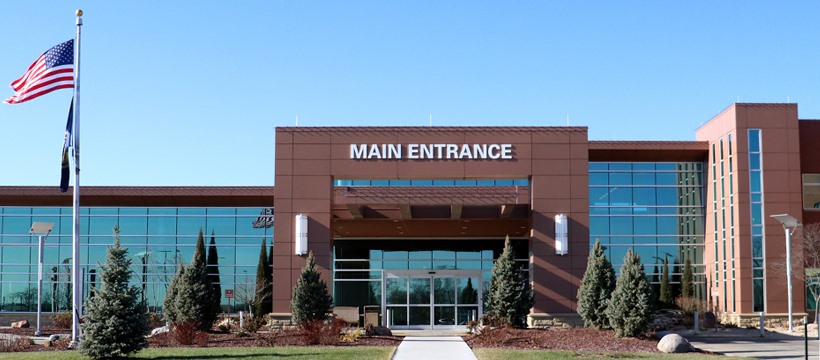 Main entrance of Beatrice Community Hospital and Health Center. Red brick building with many windows and trees our front in Beatrice, Nebraska.