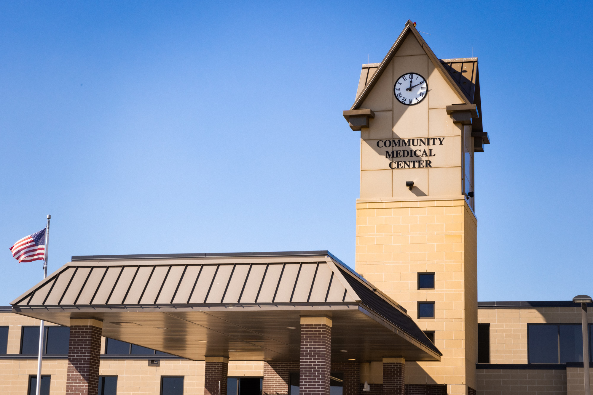 Front roof peak of the Community Medical Center in Falls City, Nebraska with a clock and drive-under awning