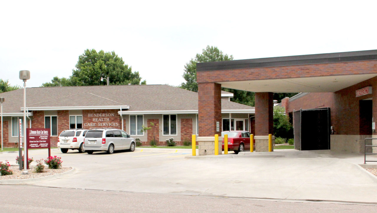 Front entrance of Henderson Health Care Services building with brick drive-under awning in Henderson, Nebraska