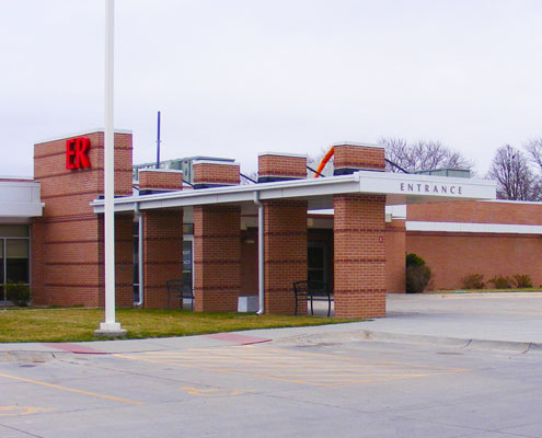 Front entrance of Jefferson Community Health and Life emergency room. Brick building with an awning and big red ER sign on the side.