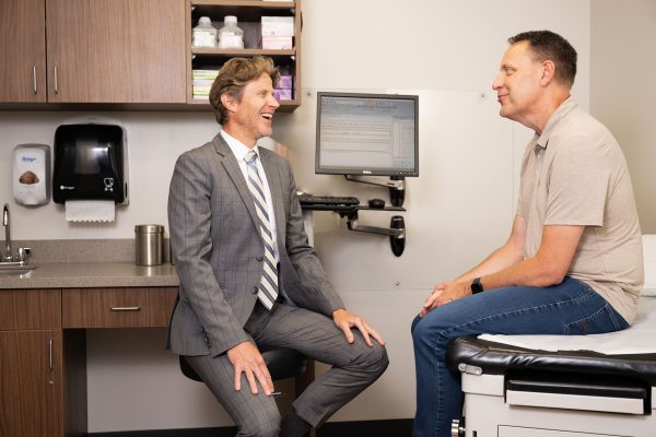 Man sitting doctors office and doctor smiling at him