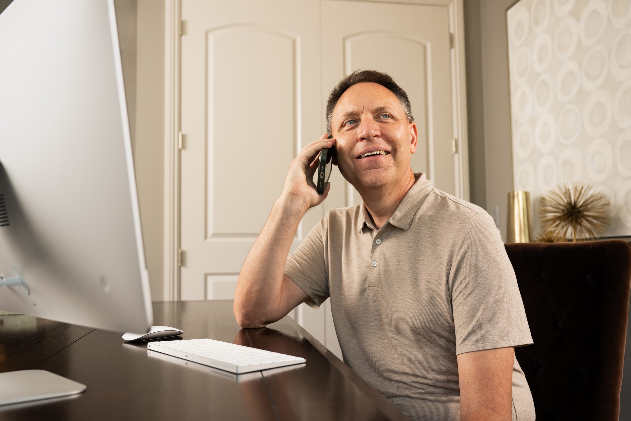 Man sitting at a desk and talking on his cell phone